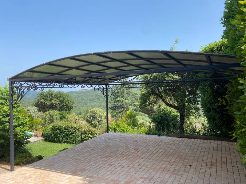 Pergola en fer forgé sur mesure Sudecor près de Èze, structure robuste avec toit polycarbonate pour confort extérieur optimal.