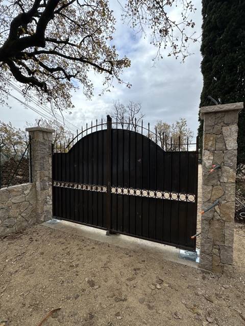 Portail plein en fer forgé moderne et sécurisé posé dans une villa à Saint-Laurent-du-Var, dans les Alpes-Maritimes.