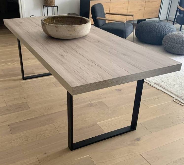Table de repas avec piètement en fer et plateau bois Sudecor installée dans un intérieur près de Fréjus, mobilier sur mesure élégant et durable.