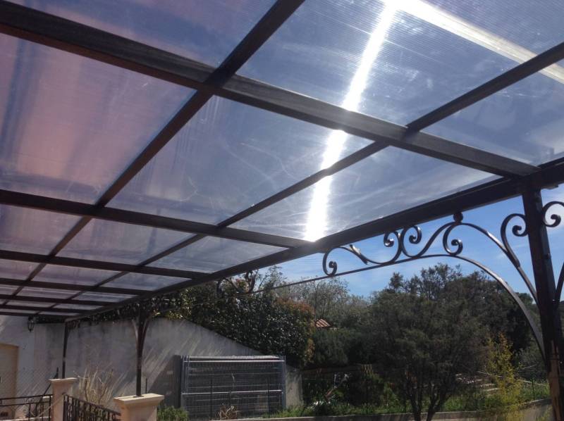 Pergola en fer forgé avec plexi réalisée par Sudecor sur une terrasse près de Carros, structure résistante et lumineuse pour extérieur.