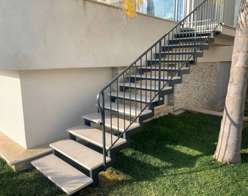 Escalier fer forgé avec marche en pierre de Thèla style travertin, pose à Cannes, Côte d'Azur